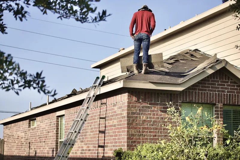 Professional roofer working on a residential roof in Coburn